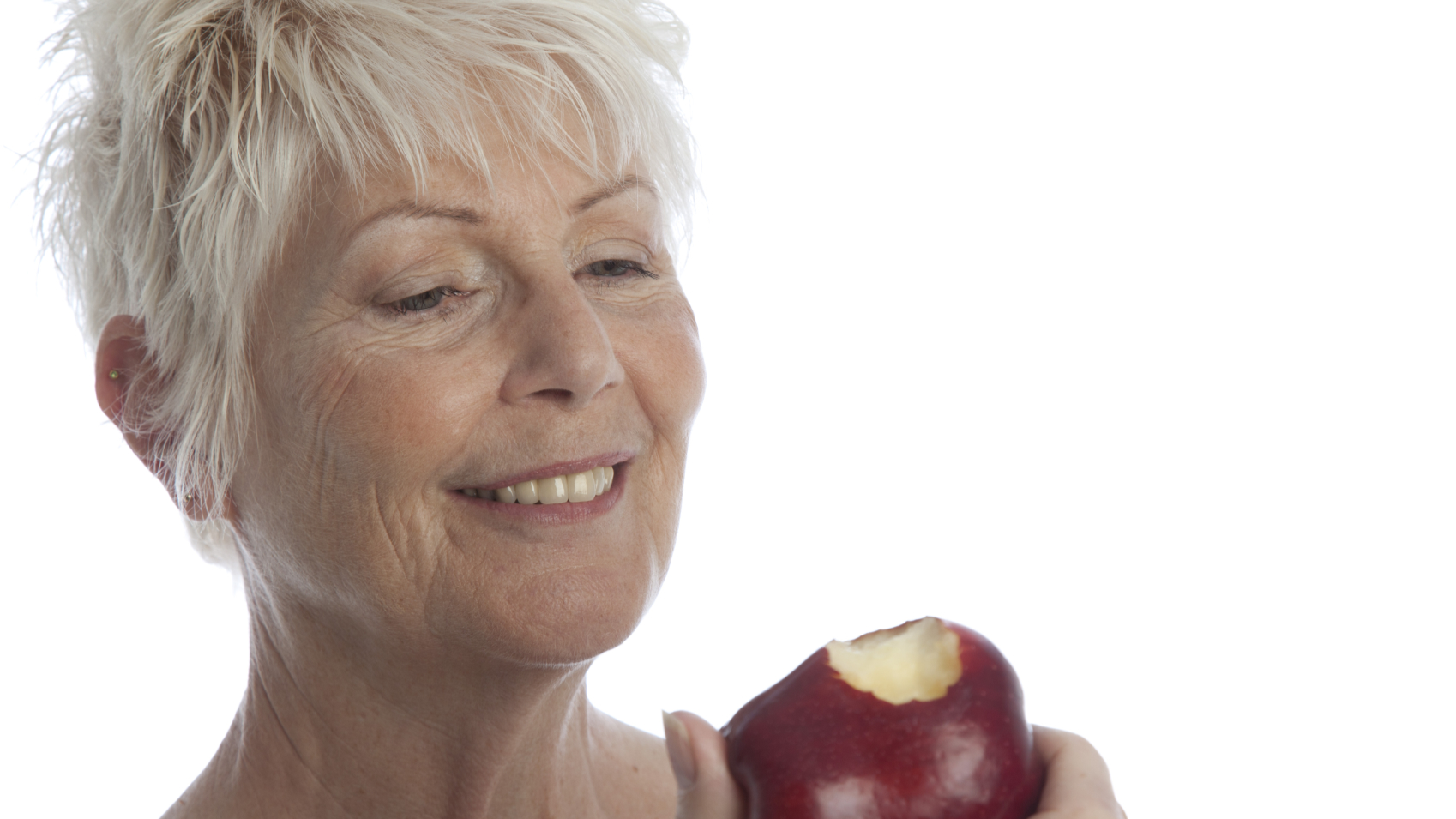 A woman eating a red apple.
