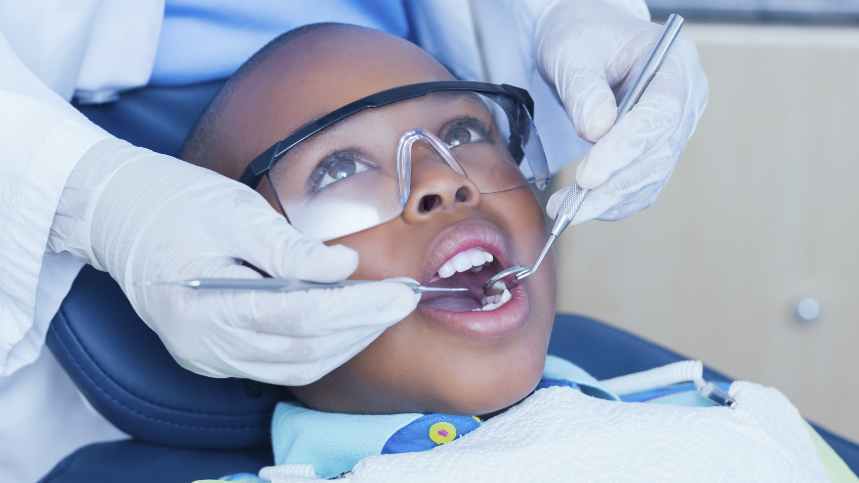 A child's mouth being examined by health care professional.