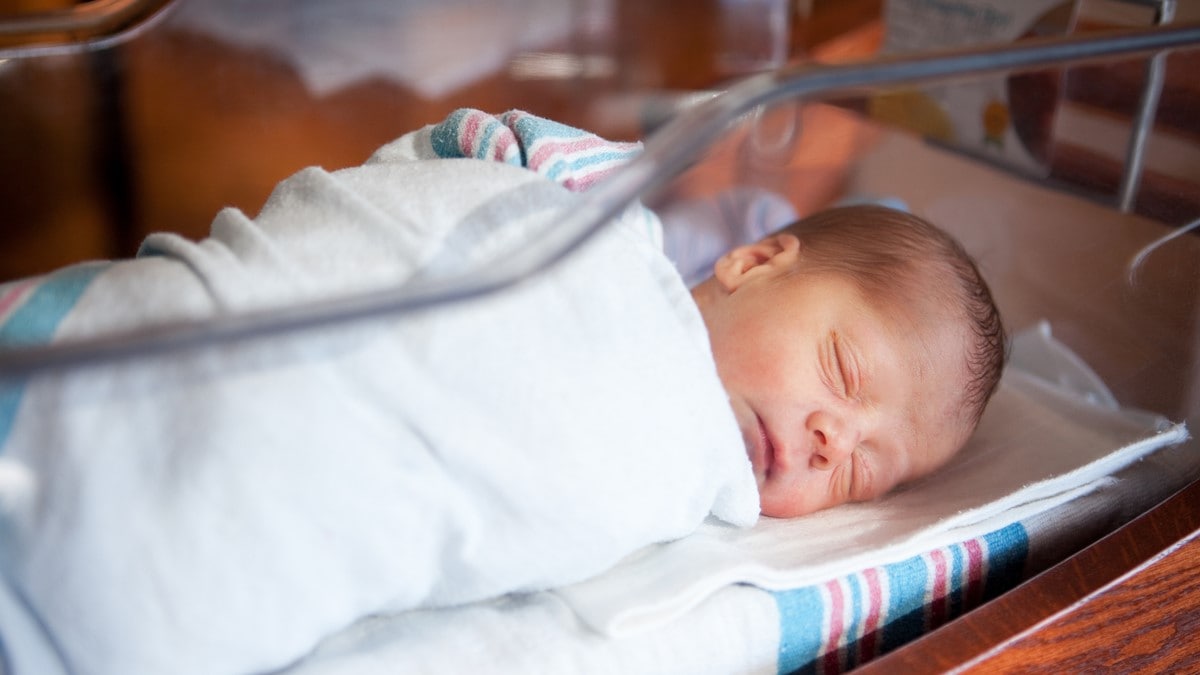 Photo of infant in hospital nursery.