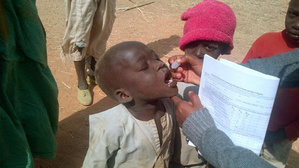Response worker taking saliva sample from child in Polio response