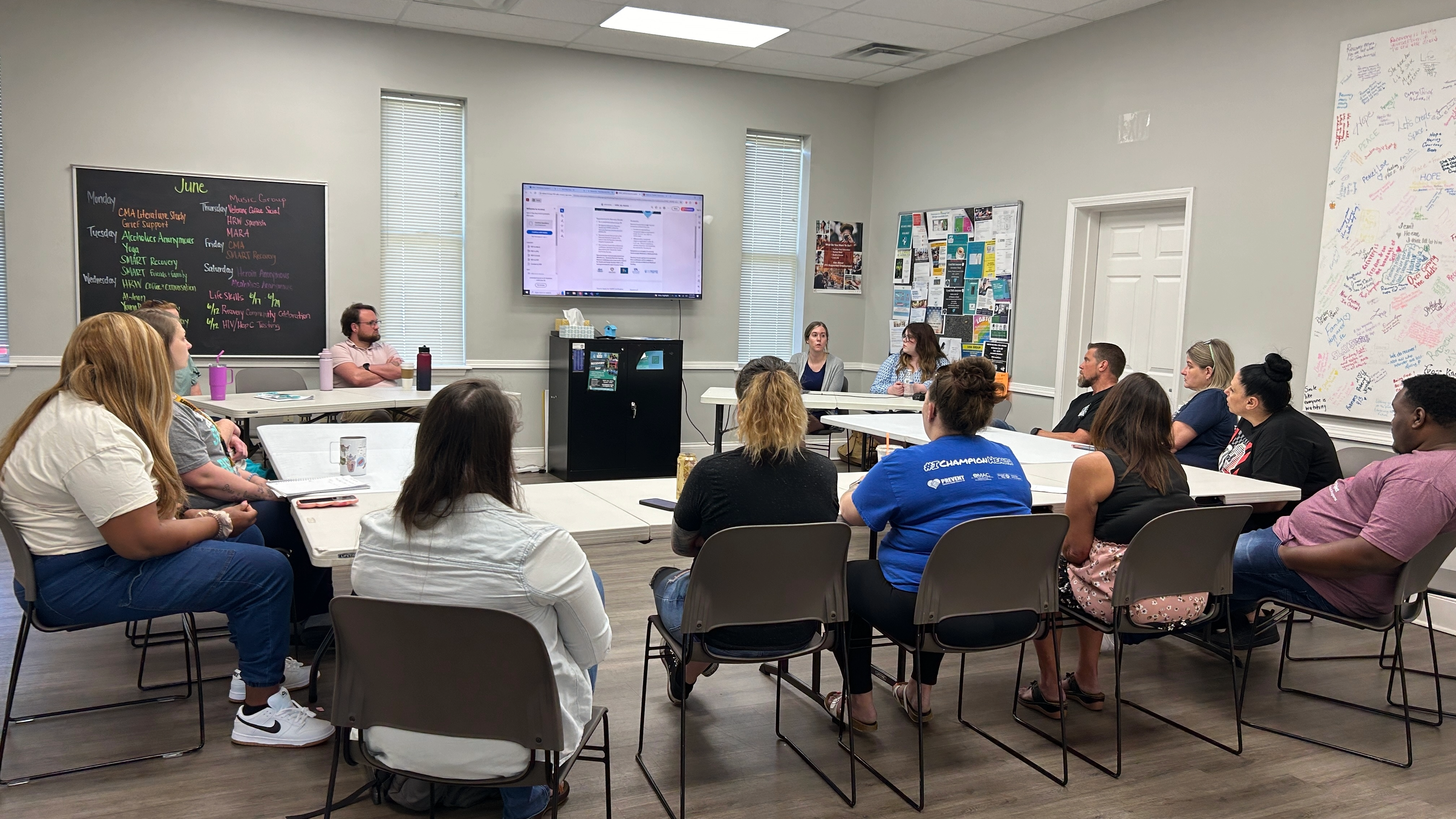 Adult recovery navigators looking at a presentation while learning how to use the FindHelpNow platform.