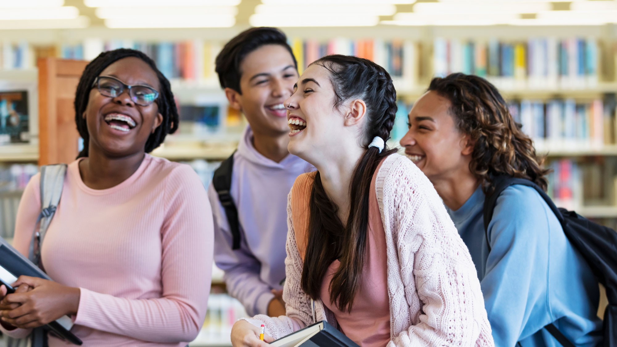 Group of teens laughing in school library