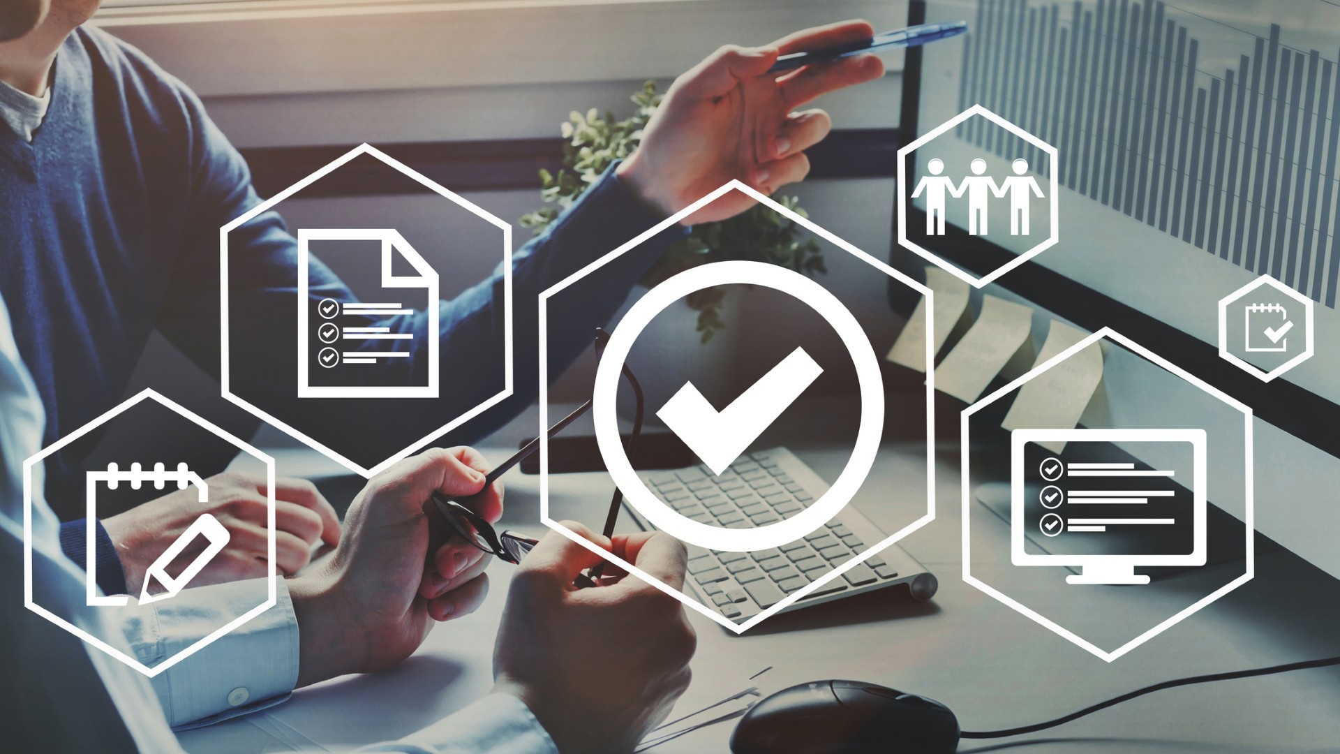 Two people pointing to a graph on a computer with data visualization icons overlayed on top of image.