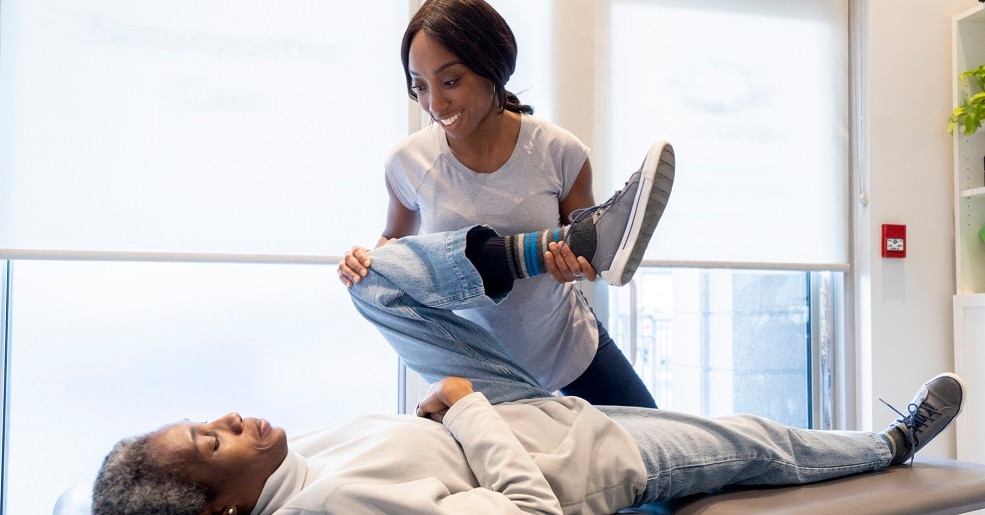 Doctor is providing physical therapy to a patient