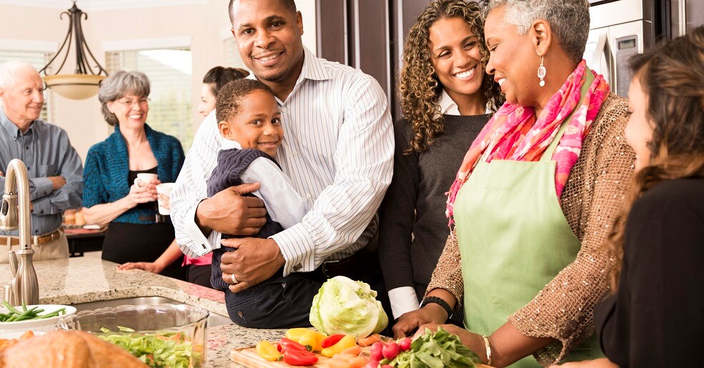 Family in kitchen preparing to eat Thanksgiving dinner