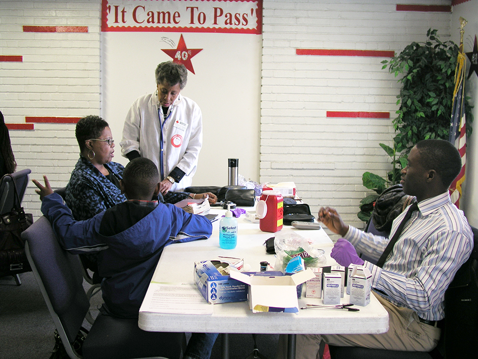 16_0386_01.jpg A volunteer nurse provides health information to a Body and Soul Program participant at a church kick-off event.