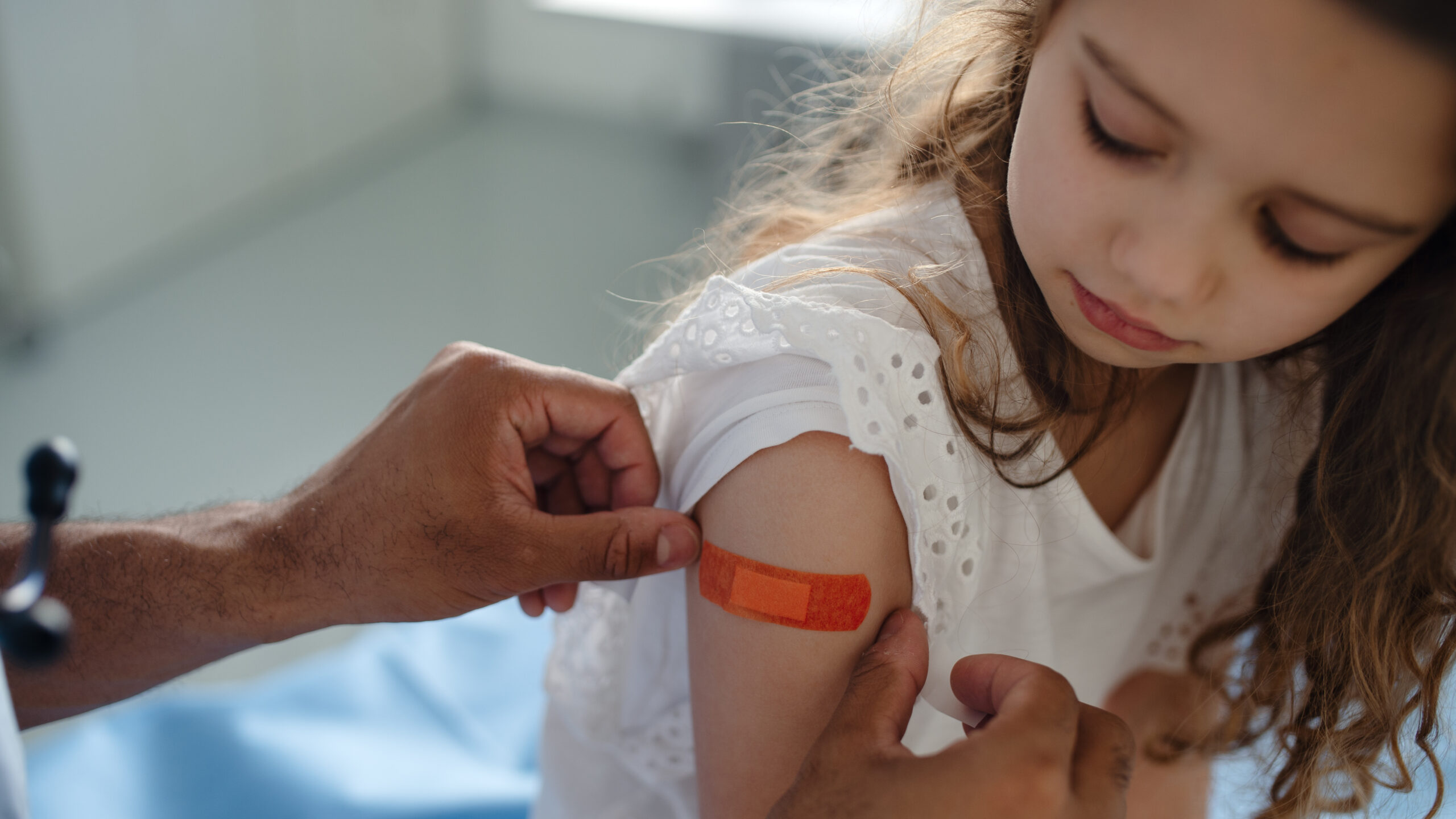 Child with bandage on arm at doctor's office.