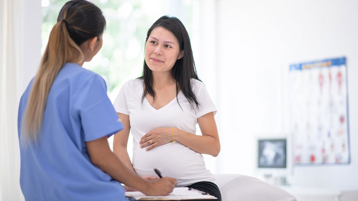 A healthcare provider talks with a pregnant patient