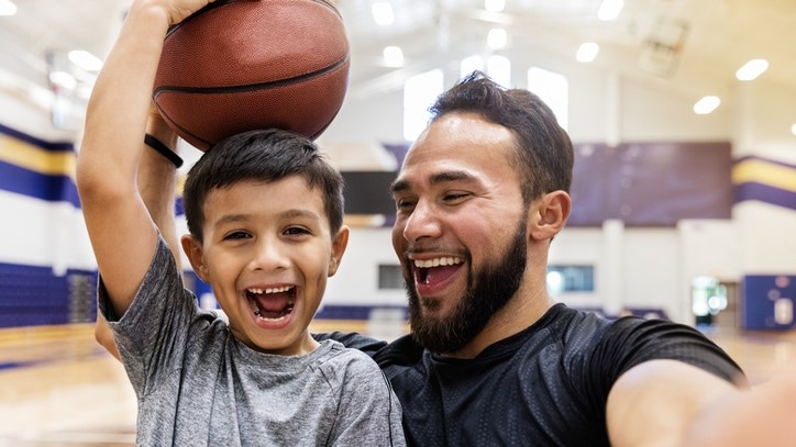 Father and son playing basketball.