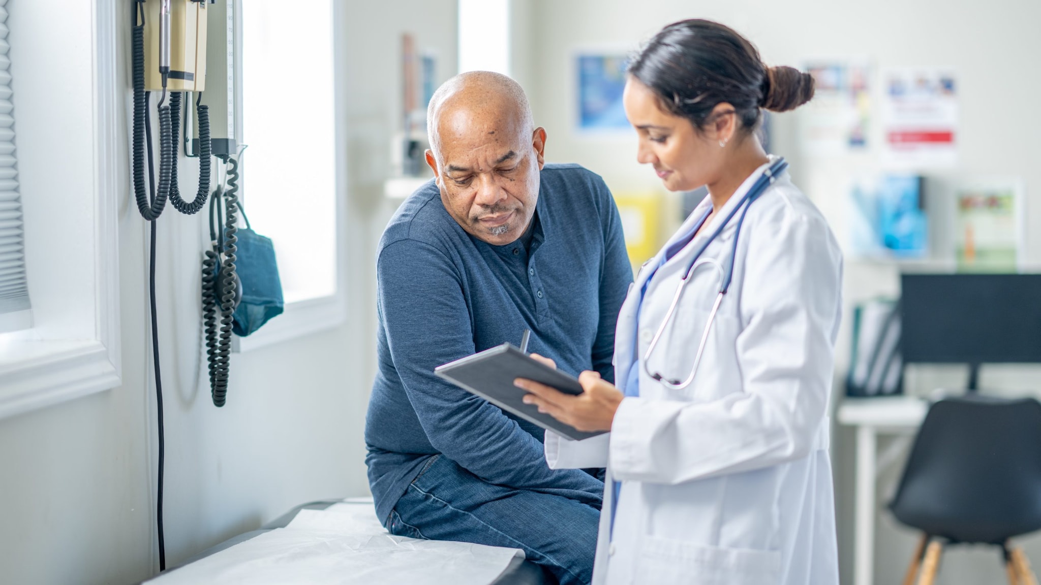 Healthcare provider and patient looking at something on a tablet during a wellness visit.