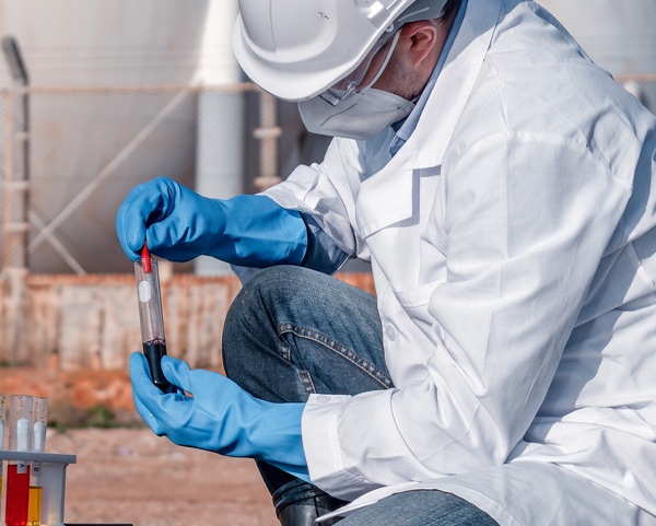 Non-laboratory potentially infectious materials guidance lab worker wearing PPE and handling samples.