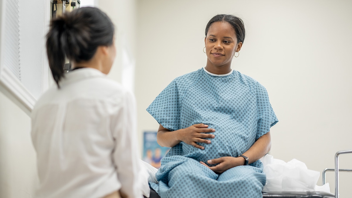 A pregnant woman receives a medical screening in a doctor's office.