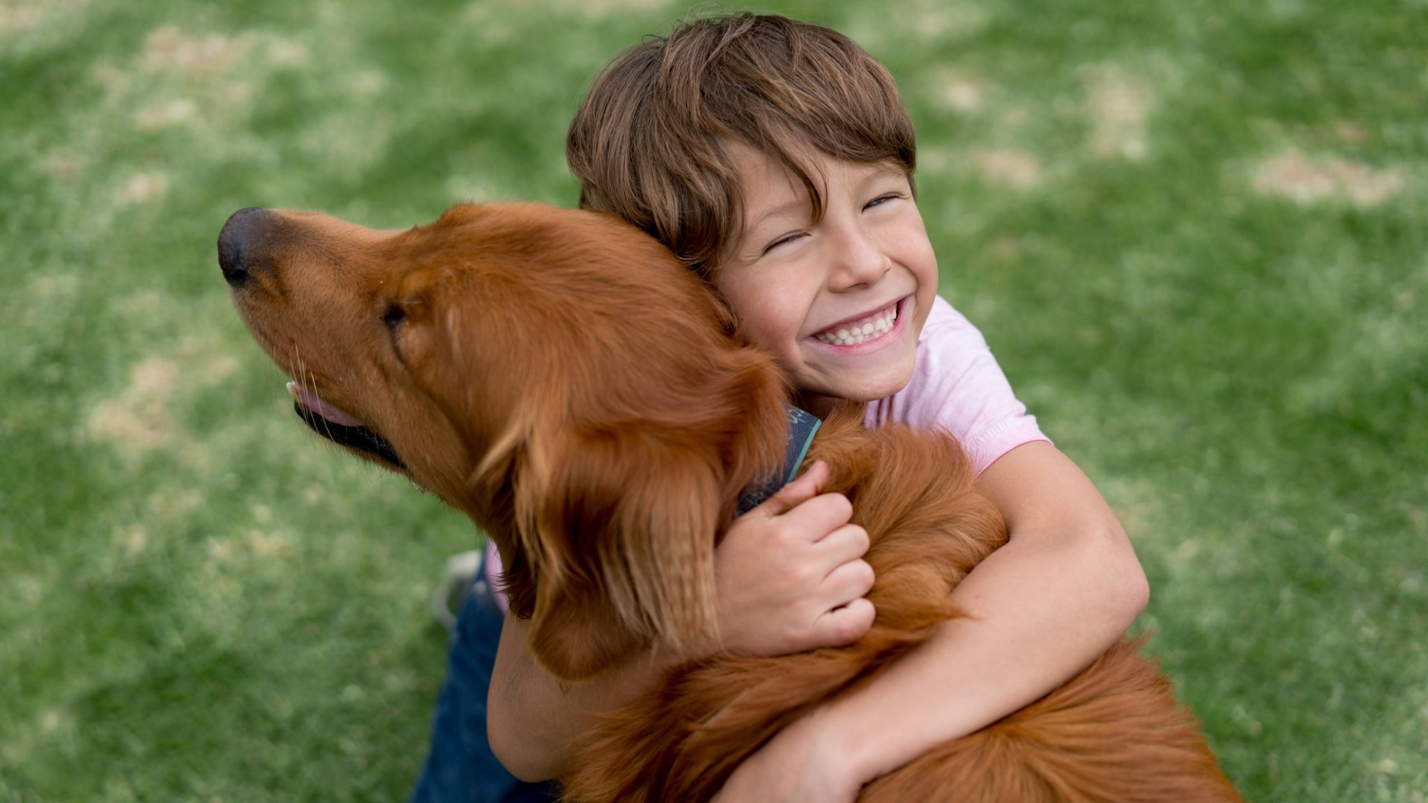 Smiling boy hugs dog