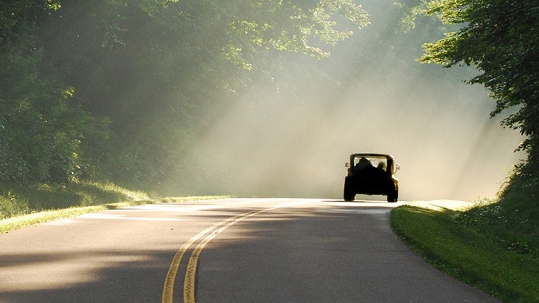 Truck driving down a rural road.