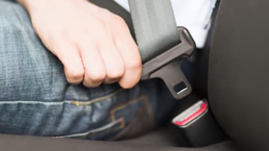 Close up of a man buckling his seat belt