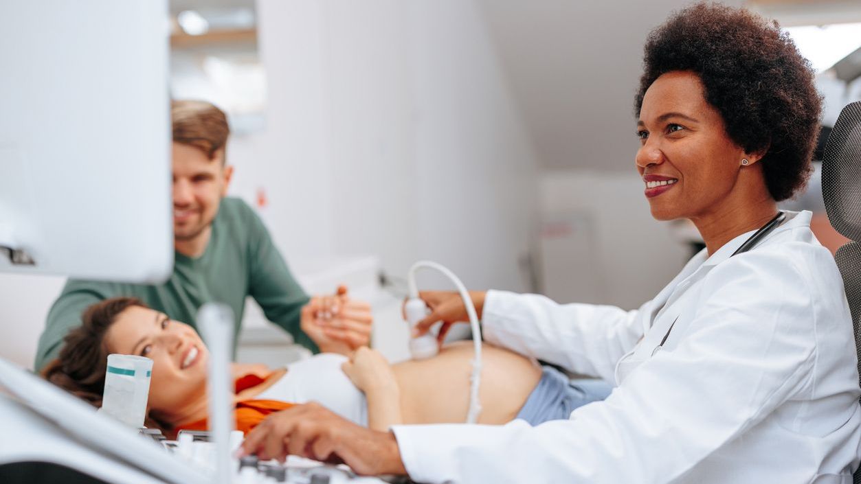 Doctor performing an ultrasound on a pregnant patient