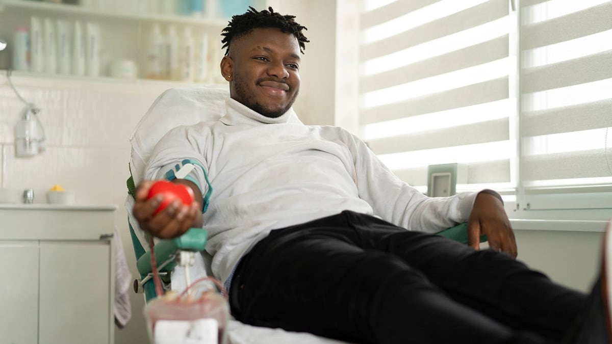 A man who is smiling while donating blood
