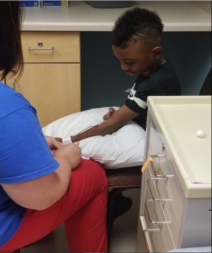 Rickey in a doctor's office chair being transfused
