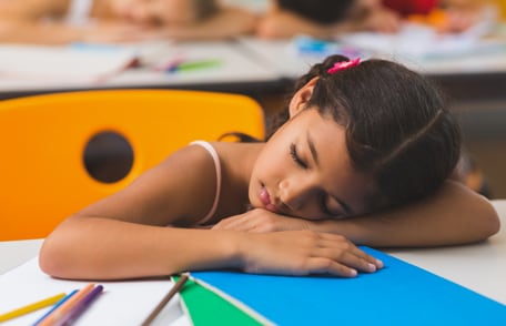 Una niña durmiendo en la clase