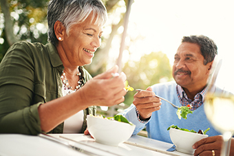 iStock-599995238-couple-eating Couple eating salad outside