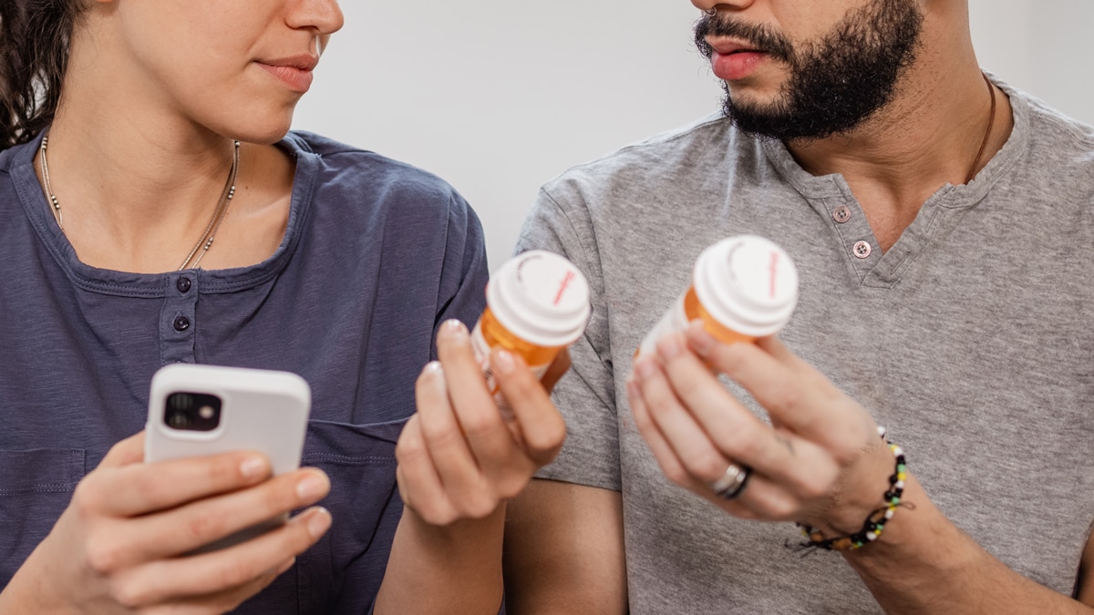 Couple holding prescription bottles