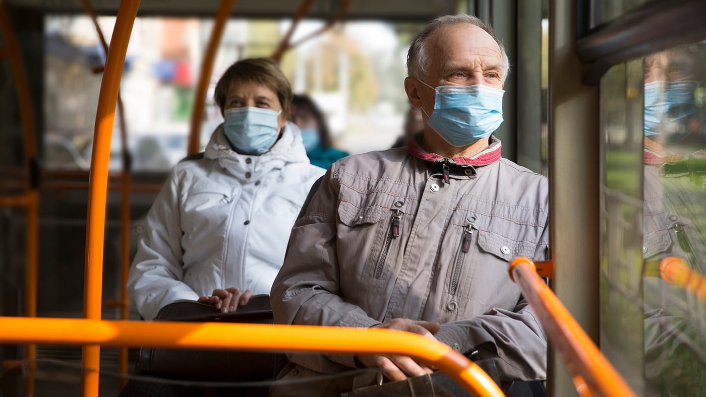Senior man wearing medical face mask sitting in the bus