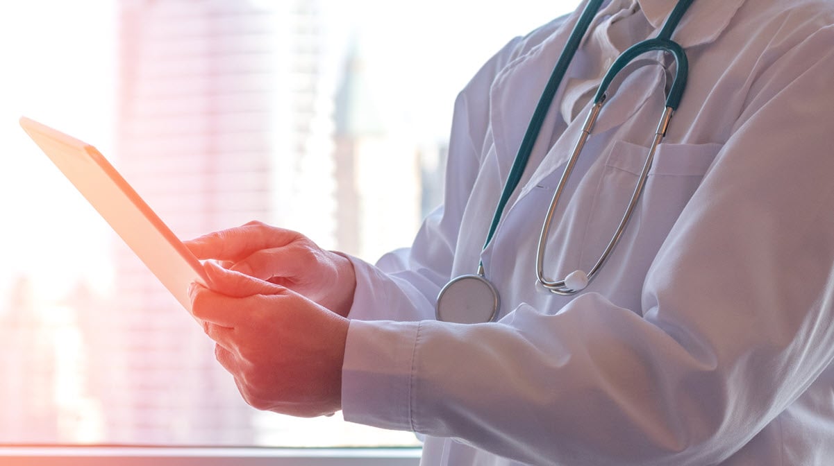 A health care provider reviews data on a tablet.