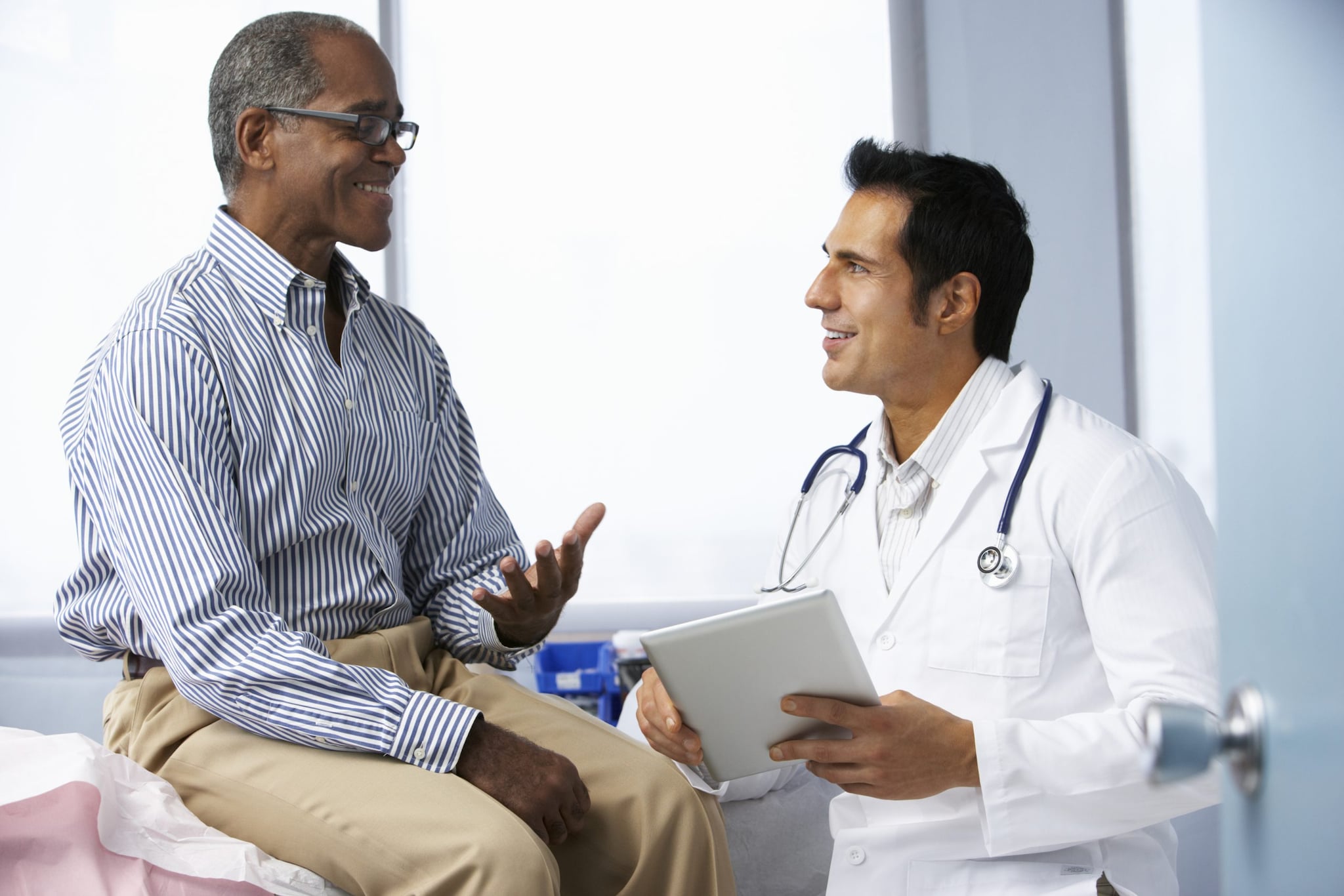 A health care provider talks to a smiling patient.