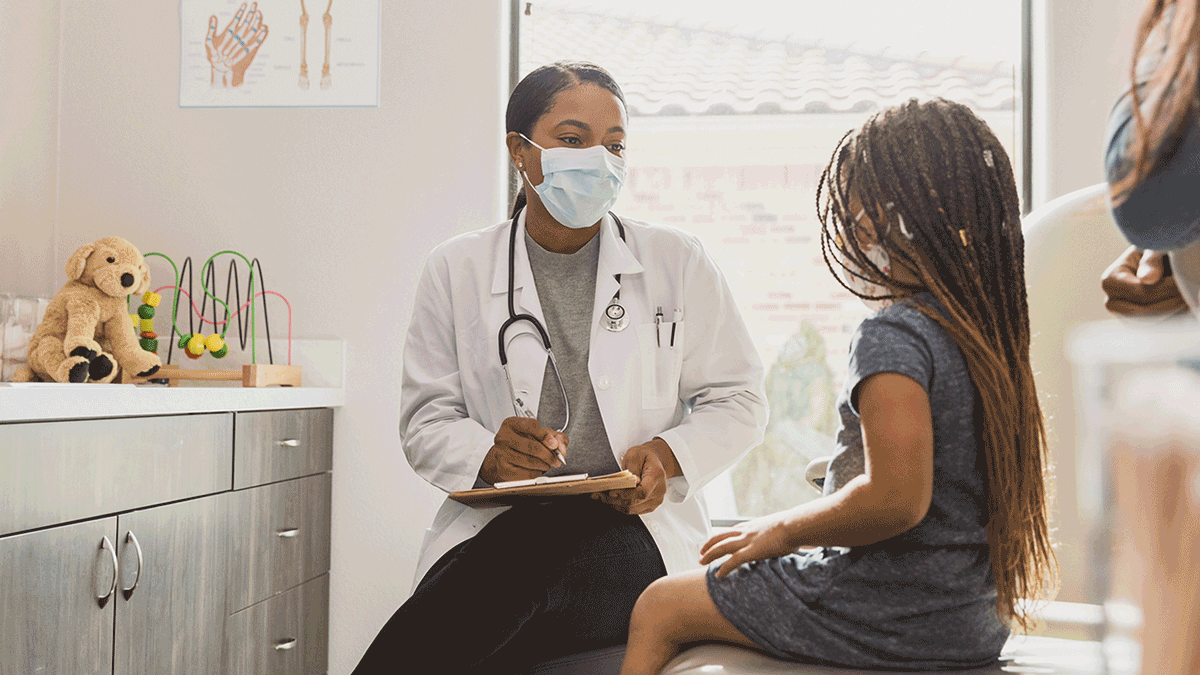 Doctor talking with young girl and mom