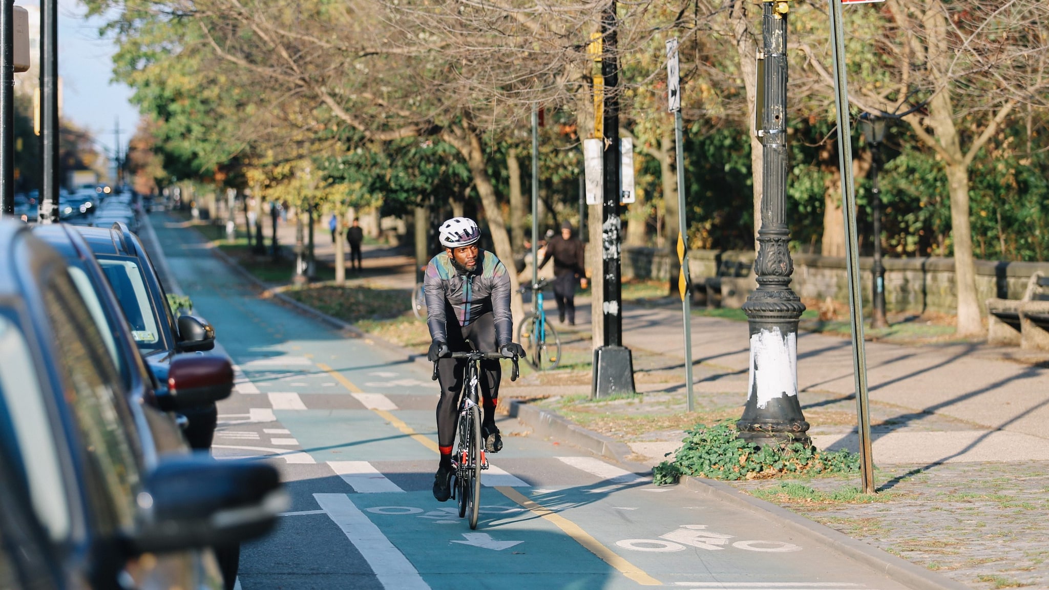 Cyclist in bike lane next to parked cars