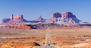Car on highway approaching Monument Valley