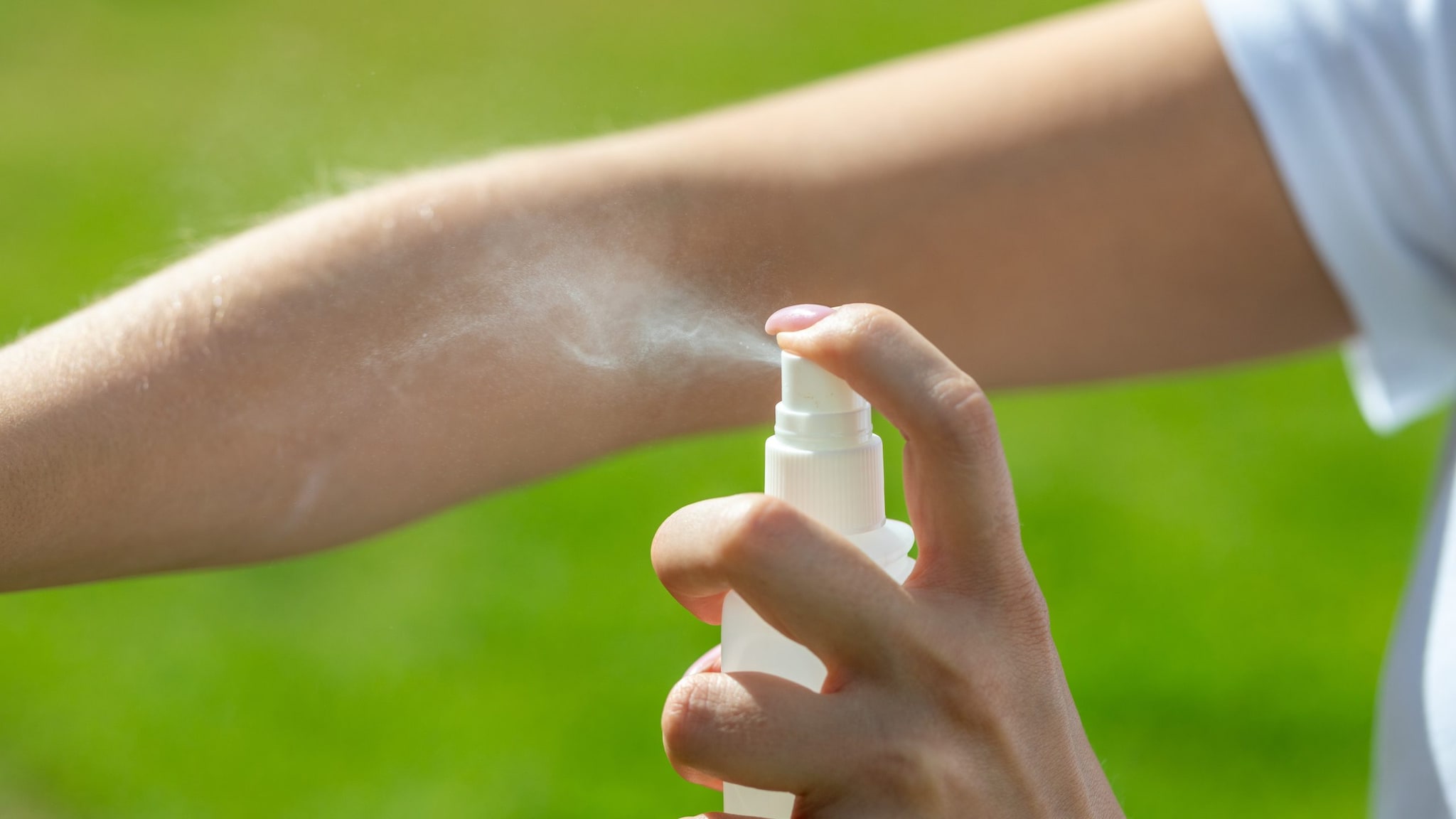 Person applying insect repellent to their arm