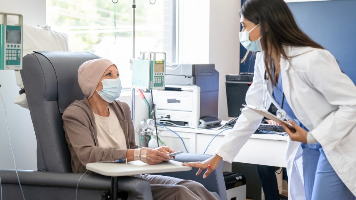 Foto de una enfermera hablando con una mujer recibiendo quimioterapia