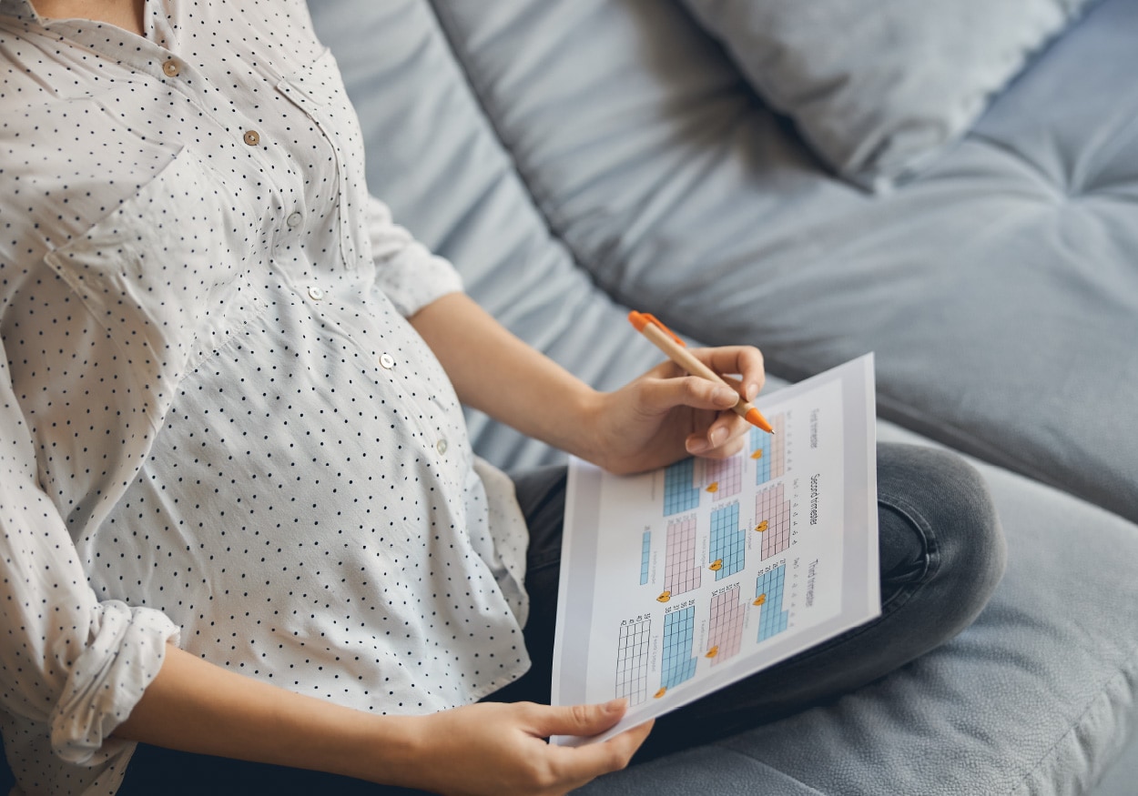 Pregnant woman marking calendar for timing vaccinations