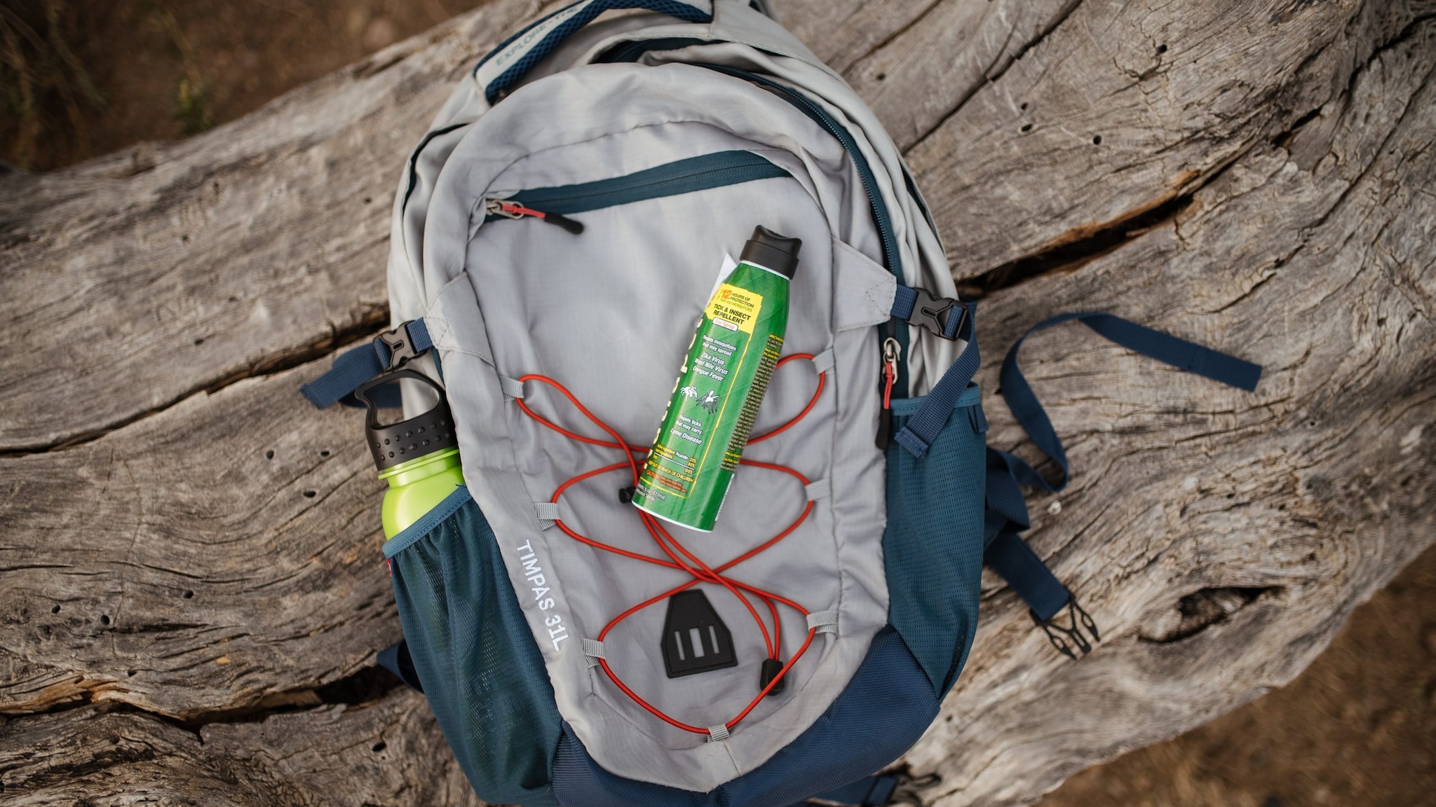 Can of insect repellent on top of a backpack.