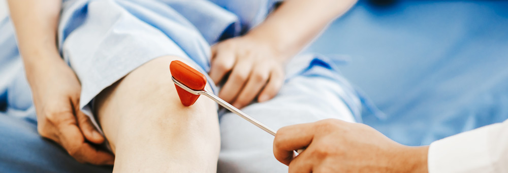 A doctor testing a patient's reflexes.