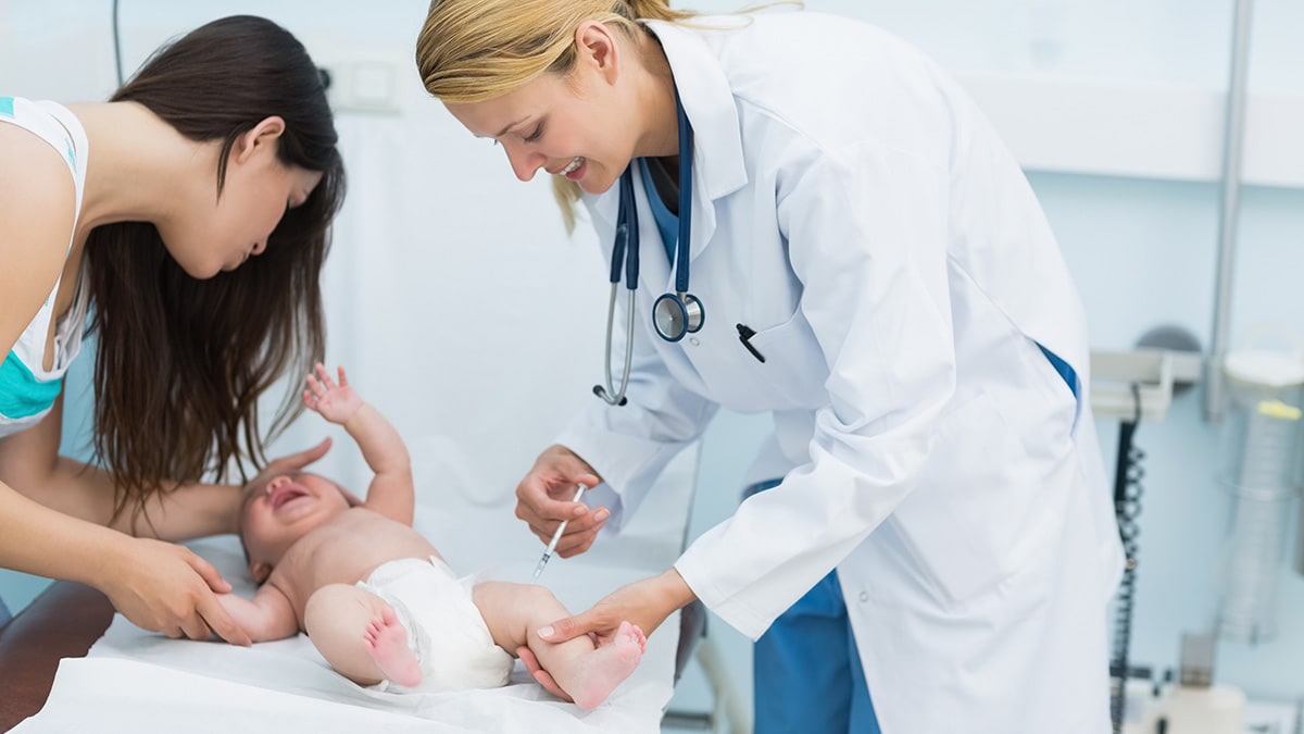 Proveedora de atención médica vacunando a un recién nacido en el hospital