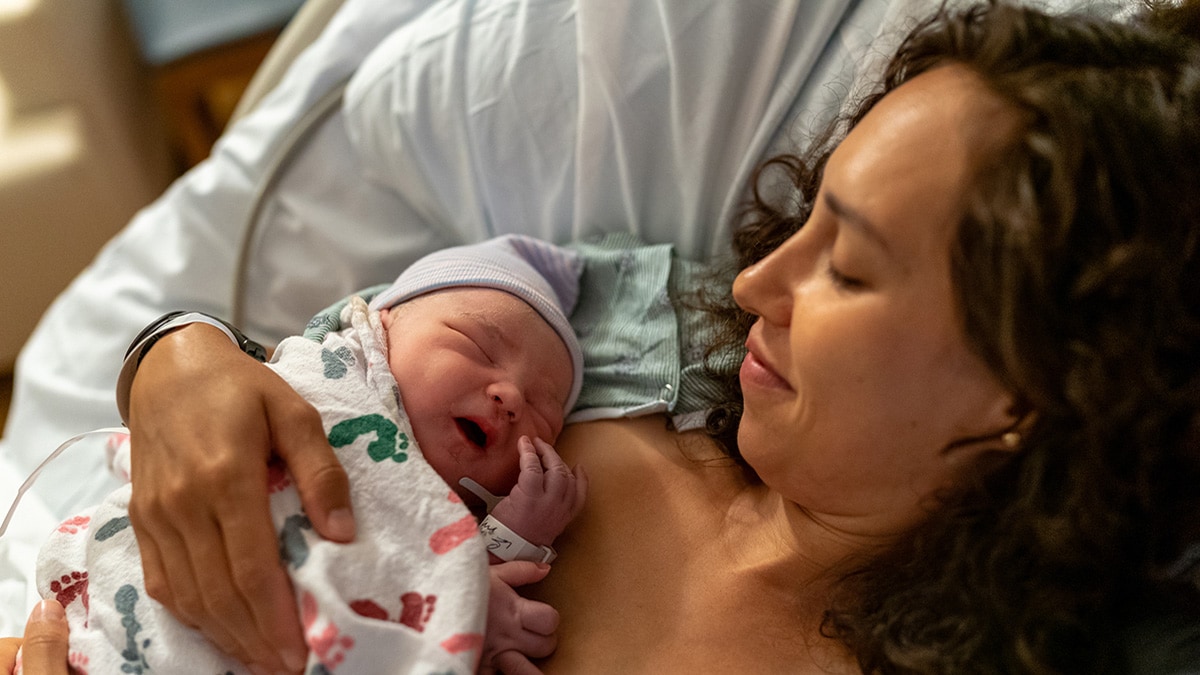 Una madre amorosa disfruta el contacto piel con piel con su bebé recién nacido