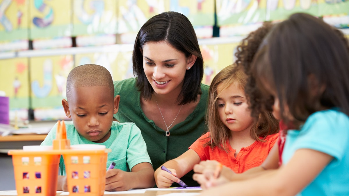 A teacher is showing kids how to draw in class.