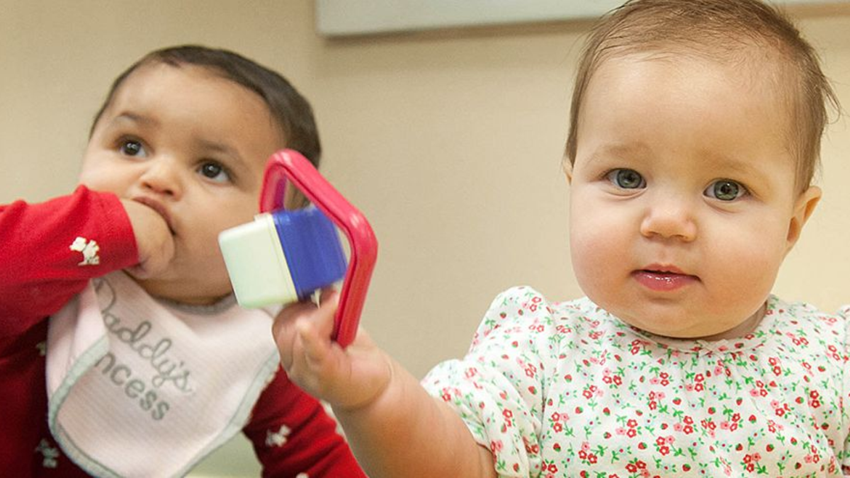 two babies playing with each other