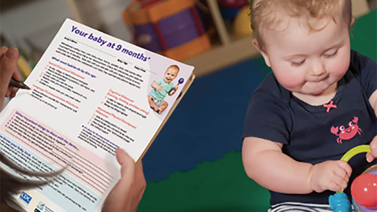 Parent reading about developmental milestones.