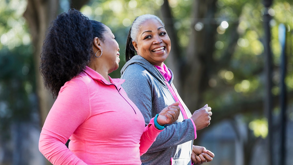 Two smiling women going on a run.