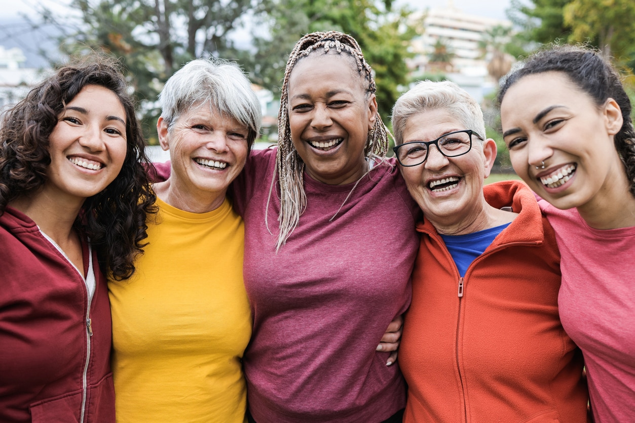 Diverse group of women and girls smiling.