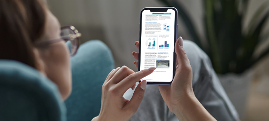 A person holding a mobile phone displaying the 2025 Annual Member Newsletter web page.