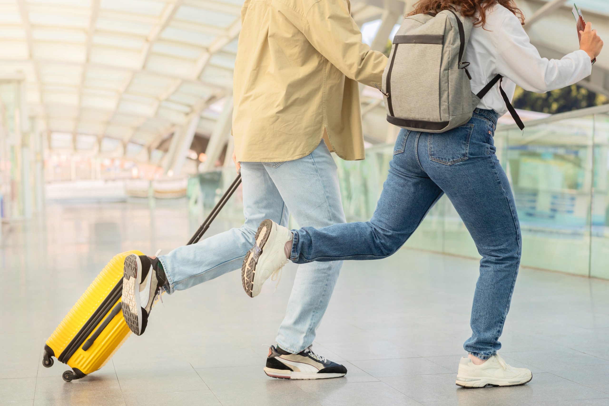 Two travelers rushing in an airport.