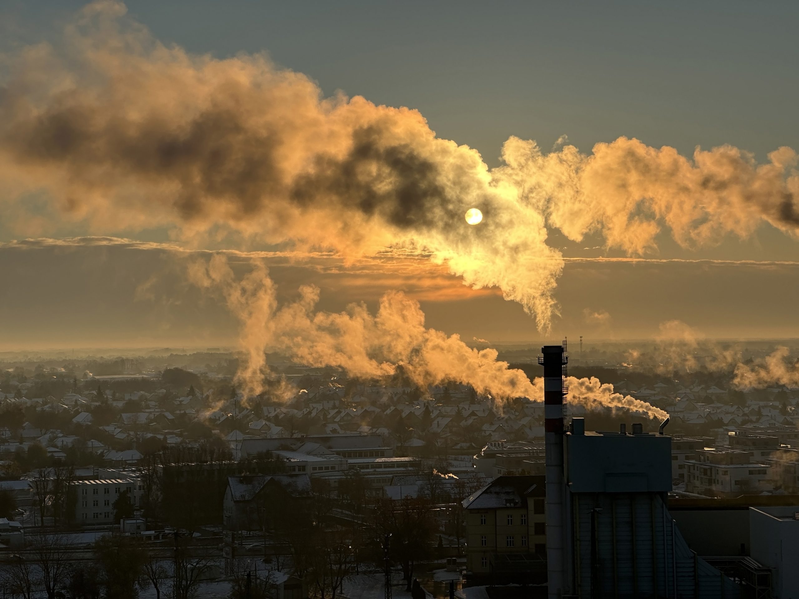 Smoke billowing from industrial buildings into the sky.