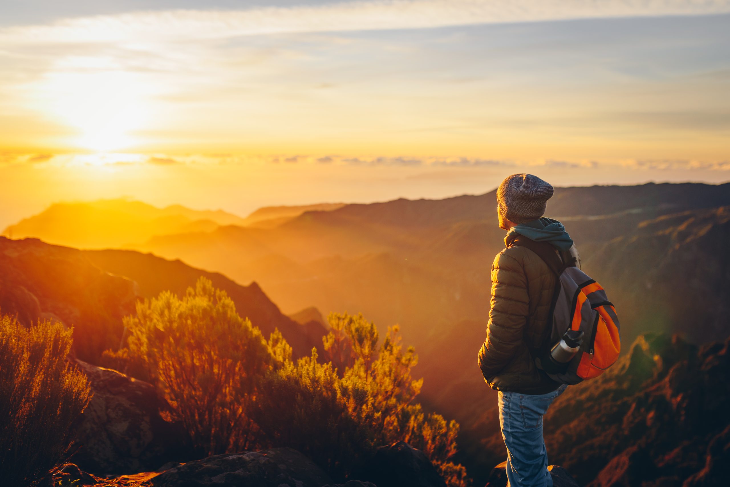 Traveler on a hike looking at the sun.