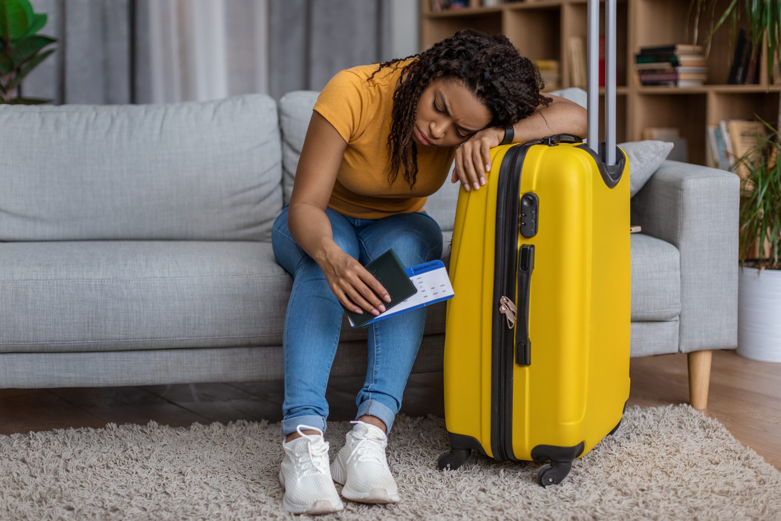 Traveler lying their head on a yellow suitcase.