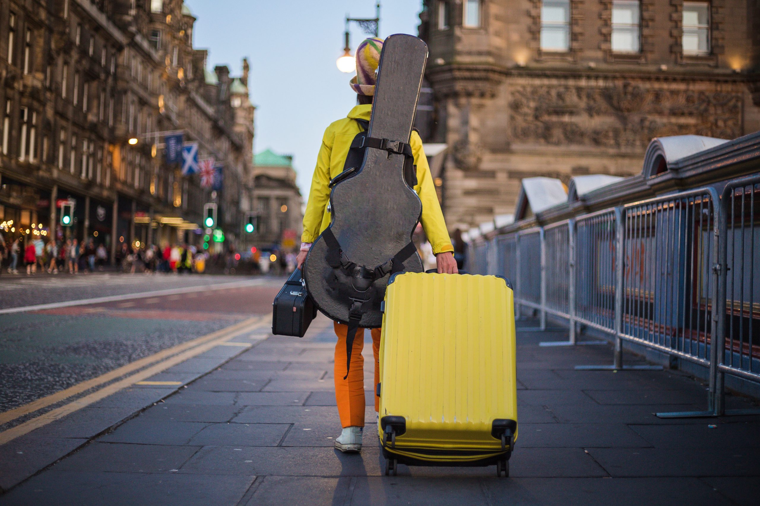 Traveler pulling a yellow suitcase.