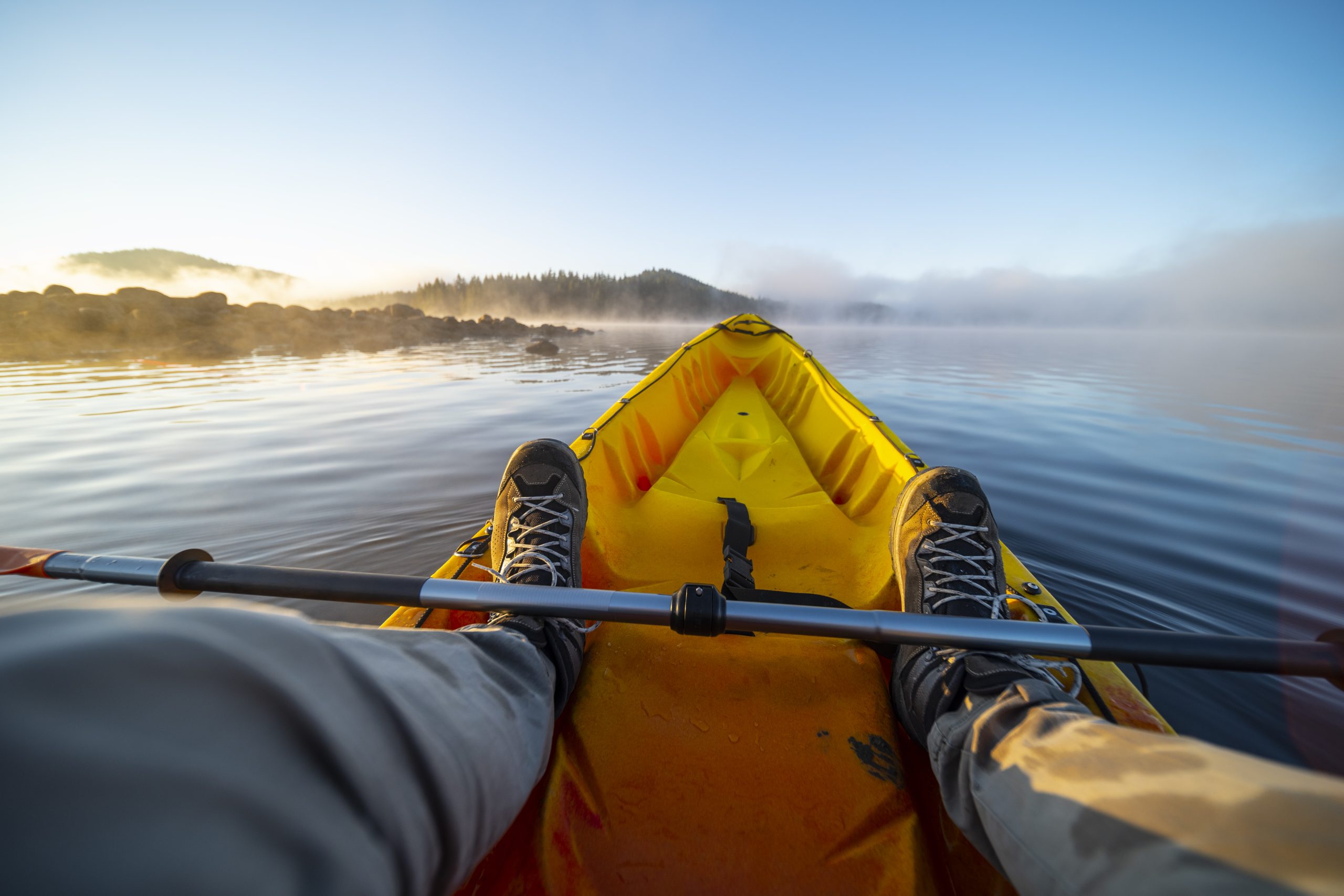 Traveler kayaking in a lake at sunrise.